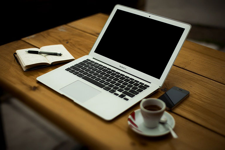 laptop with mug on home table