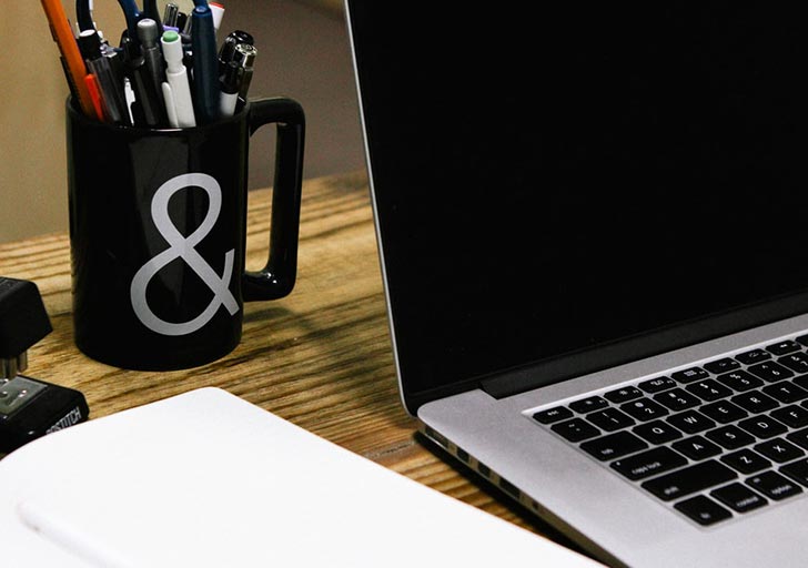 laptop with mug on table