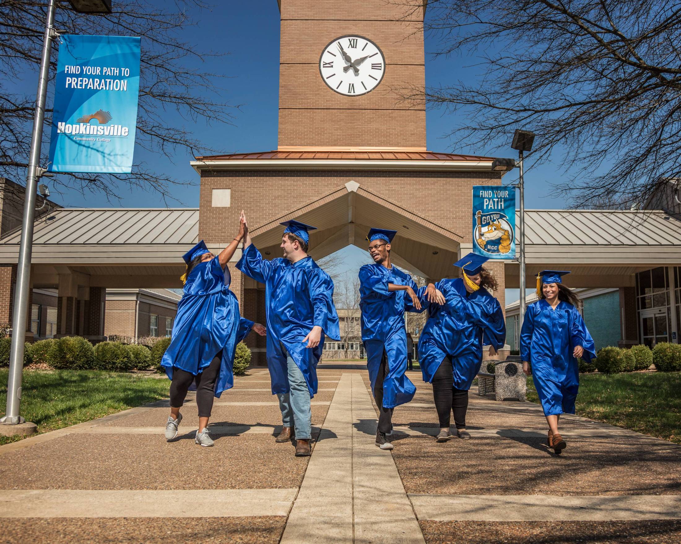 Hopkinsville graduates walking down path by clock tower 